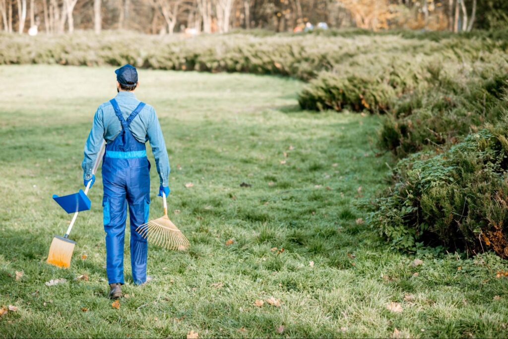 A gardener carries tools for cleaning before applying weed control for lawns.