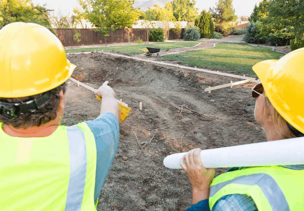 Two construction workers are overlooking the landscape.