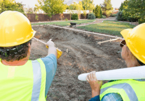 Two construction workers are overlooking the landscape.